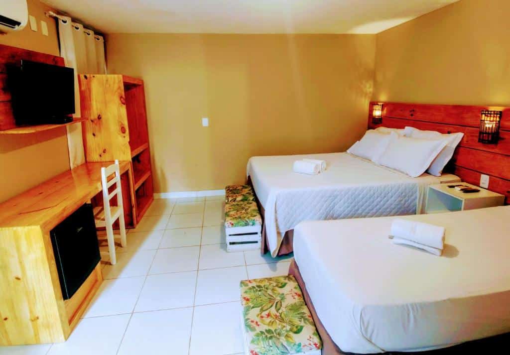 Quarto duplo com TV e frigobar e mesa de trabalho na Vila Aju, uma das pousadas em Aracaju