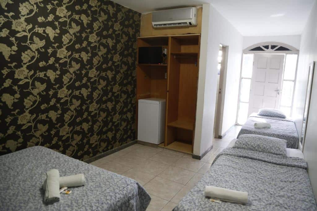Quarto da Pousada da Terra, em Aracaju, com camas, ar-conicionado e frigobar