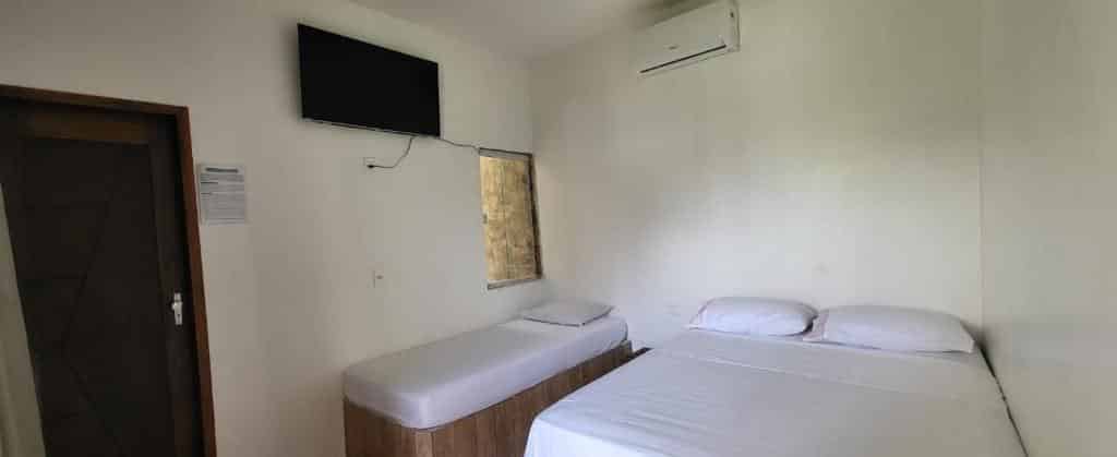 Quarto da Villa Atalaia com uma cama de casal, uma cama de solteiro, TV e ar-condicionado