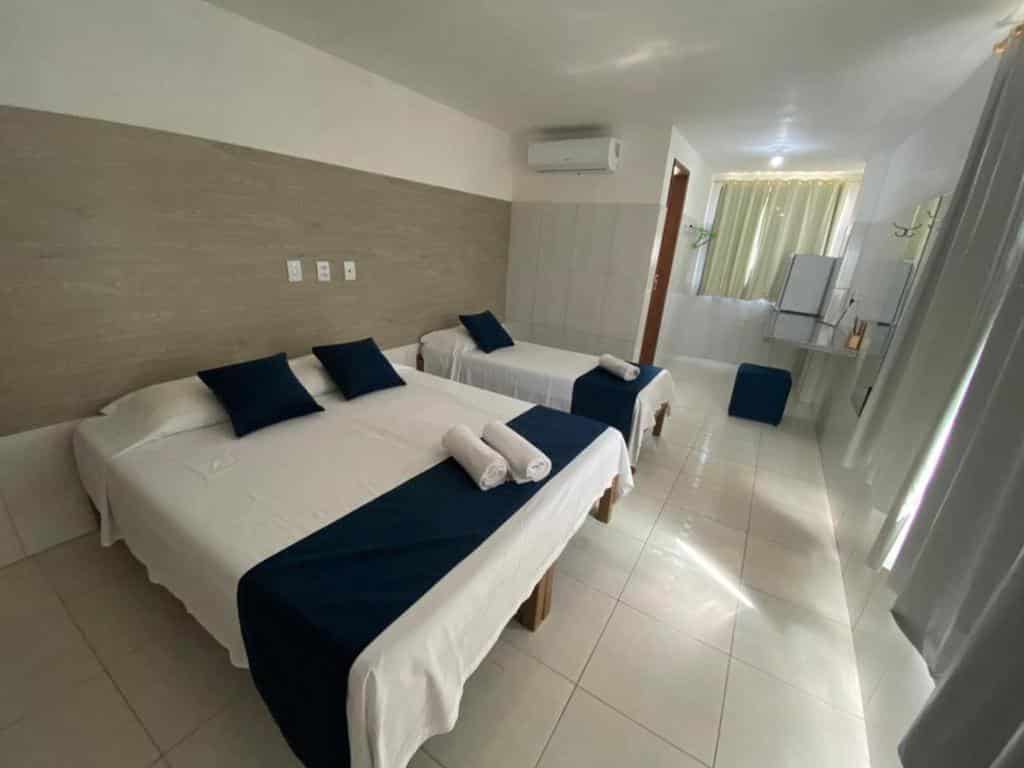 Quarto da Infinity, em Aracaju, com uma cama de casal, uma cama de solteiro, ar-condicionado e frigobar