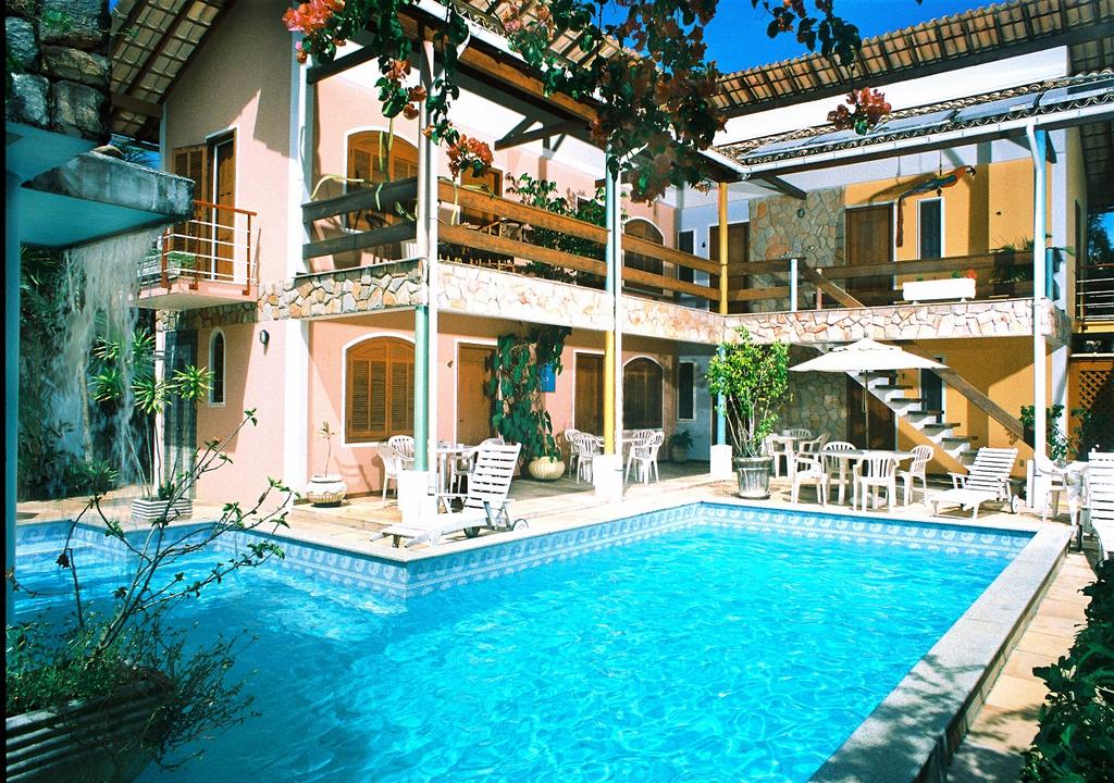 Pousada Vitória em Ilhéus, com piscina ao ar livre, mesas, cadeiras e espreguiçadeiras