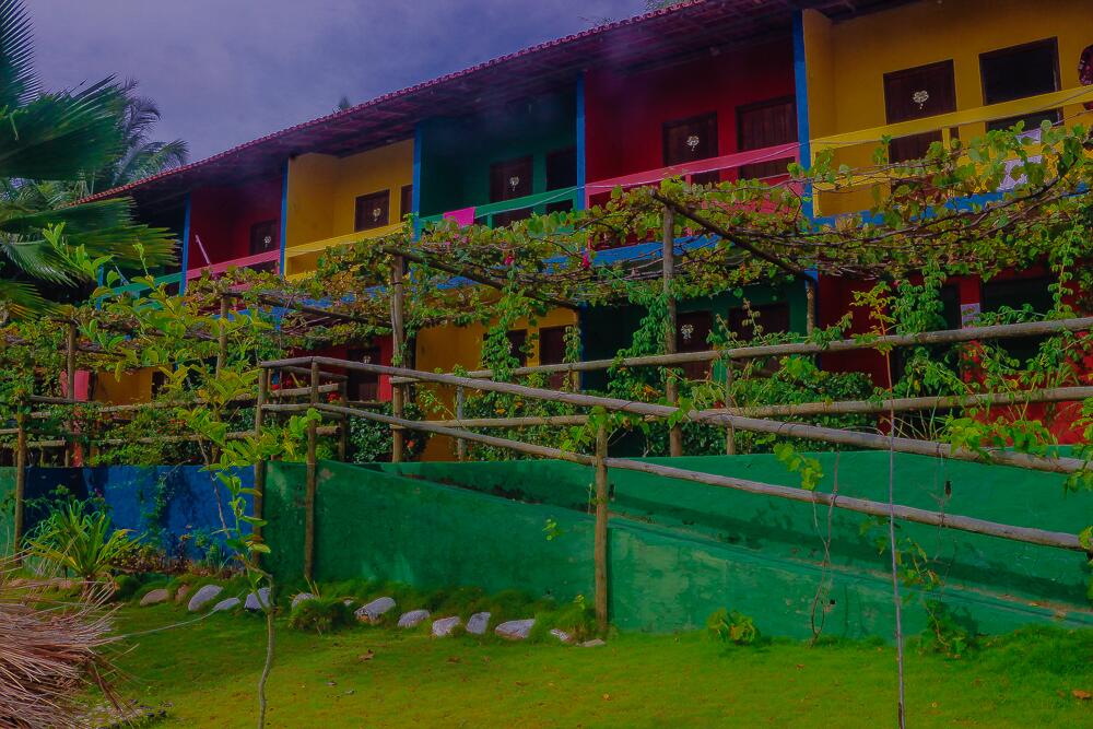 Vista externa dos sobrados do Chalés Costa do Sol em Ilhéus, de cores diversas