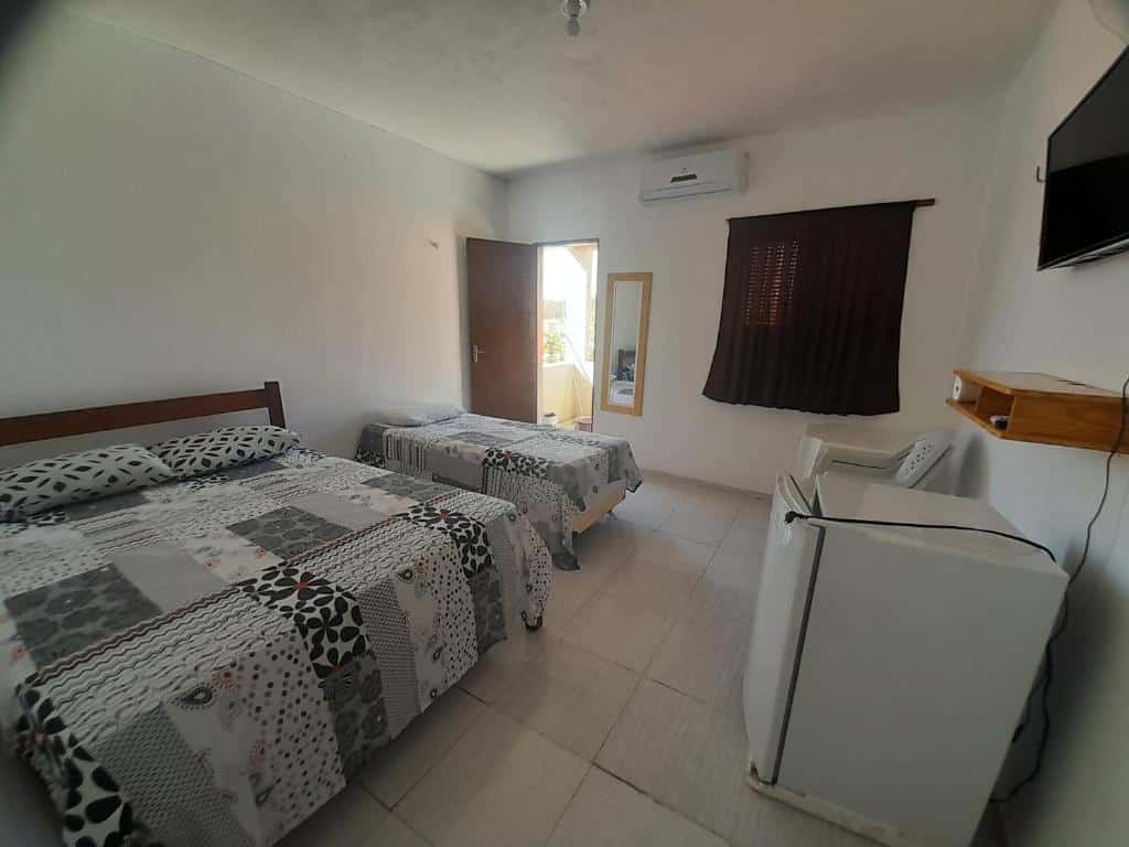 Quarto da Pousada Progresso com cama de casal e uma de solteiro.