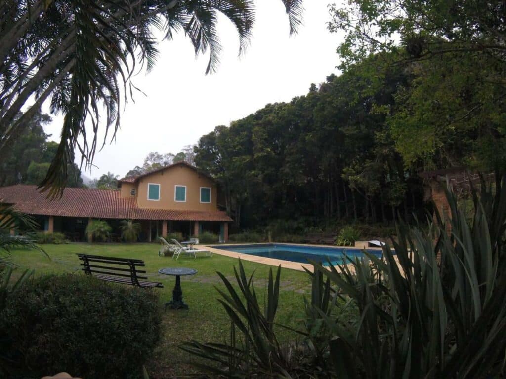 Parte de trás da Pousada Amoedo, área ampla de natureza, com a piscina ao centro. 