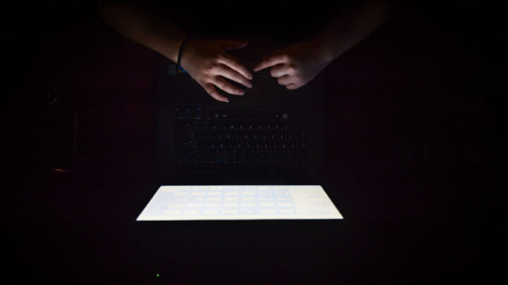 Imagem escura, cuja única luz provém do ecrã de um computador, a representar ver pornografia.