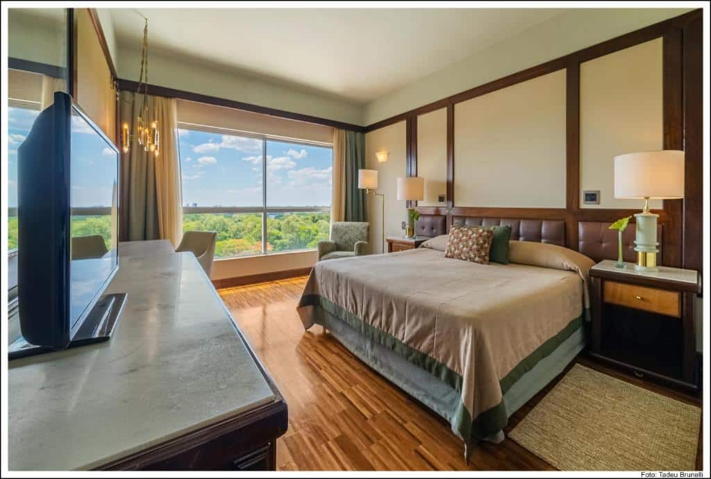 Quarto com cama de casal e vista para a natureza do Bourbon Cataratas do Iguaçu, um dos resorts para o Réveillon