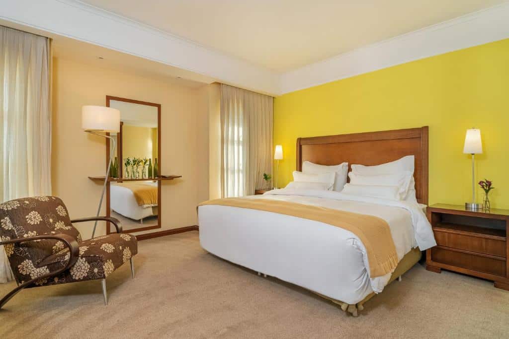 Quarto do Bourbon Atibaia Resort, com uma cama de casal macia e uma poltrona ao lado