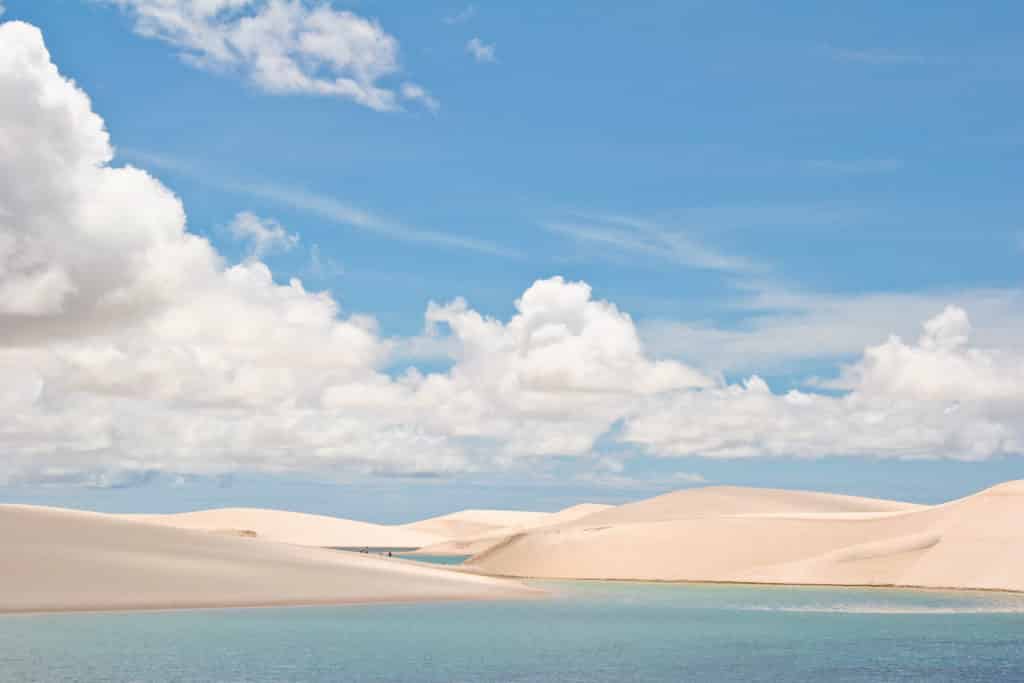 Os Lençóis Maranhenses em dia de céu azul com nuvens, com as dunas em volta de lagos de água clara