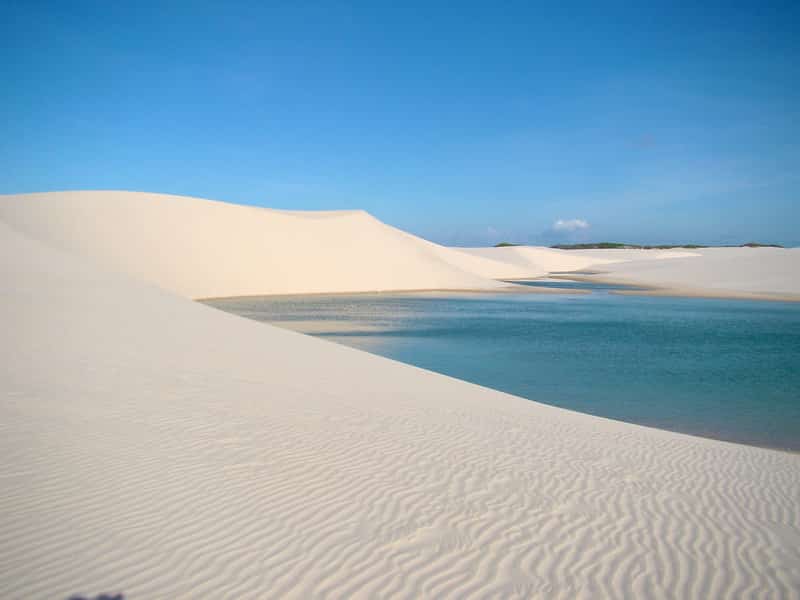 Foto em área com dunas de areia fina e branca e lagos naturais no caminho entre Barreirinhas, Atins e Caburé, na Rota das Emoções